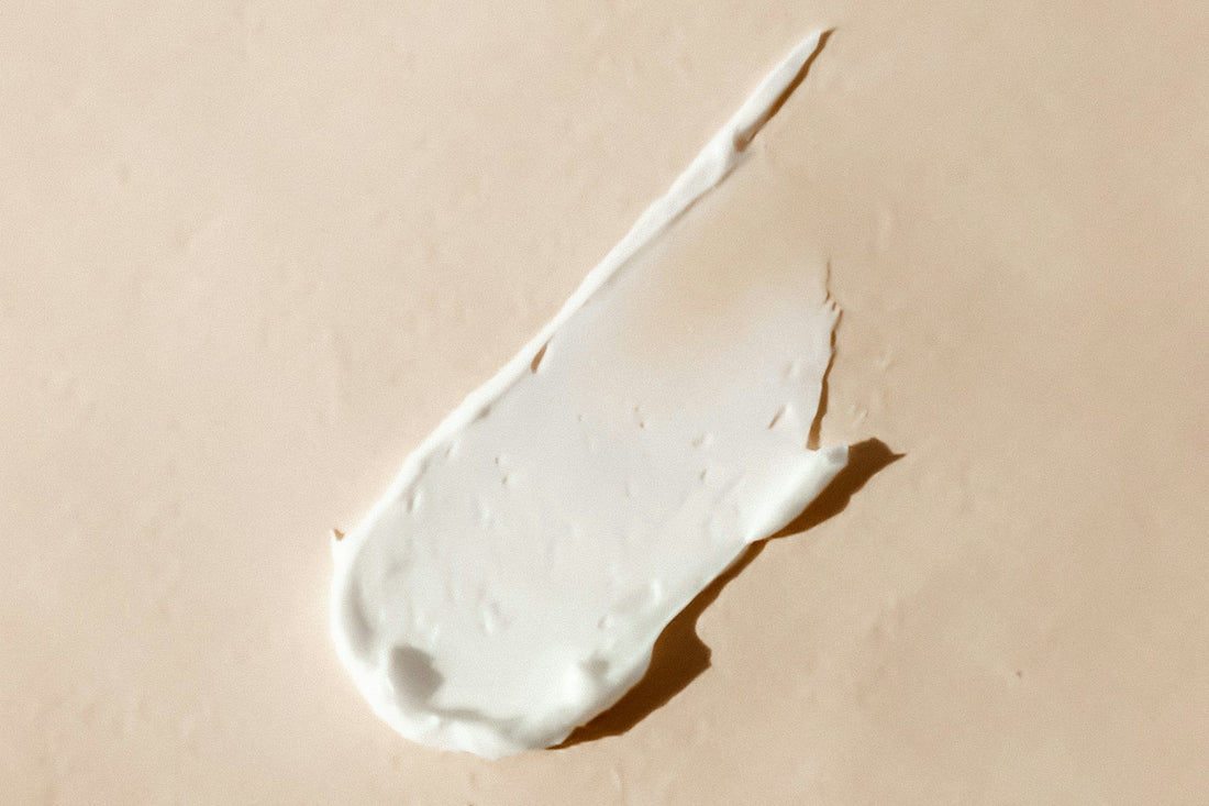 En klat hvid creme på en lys beige baggrund