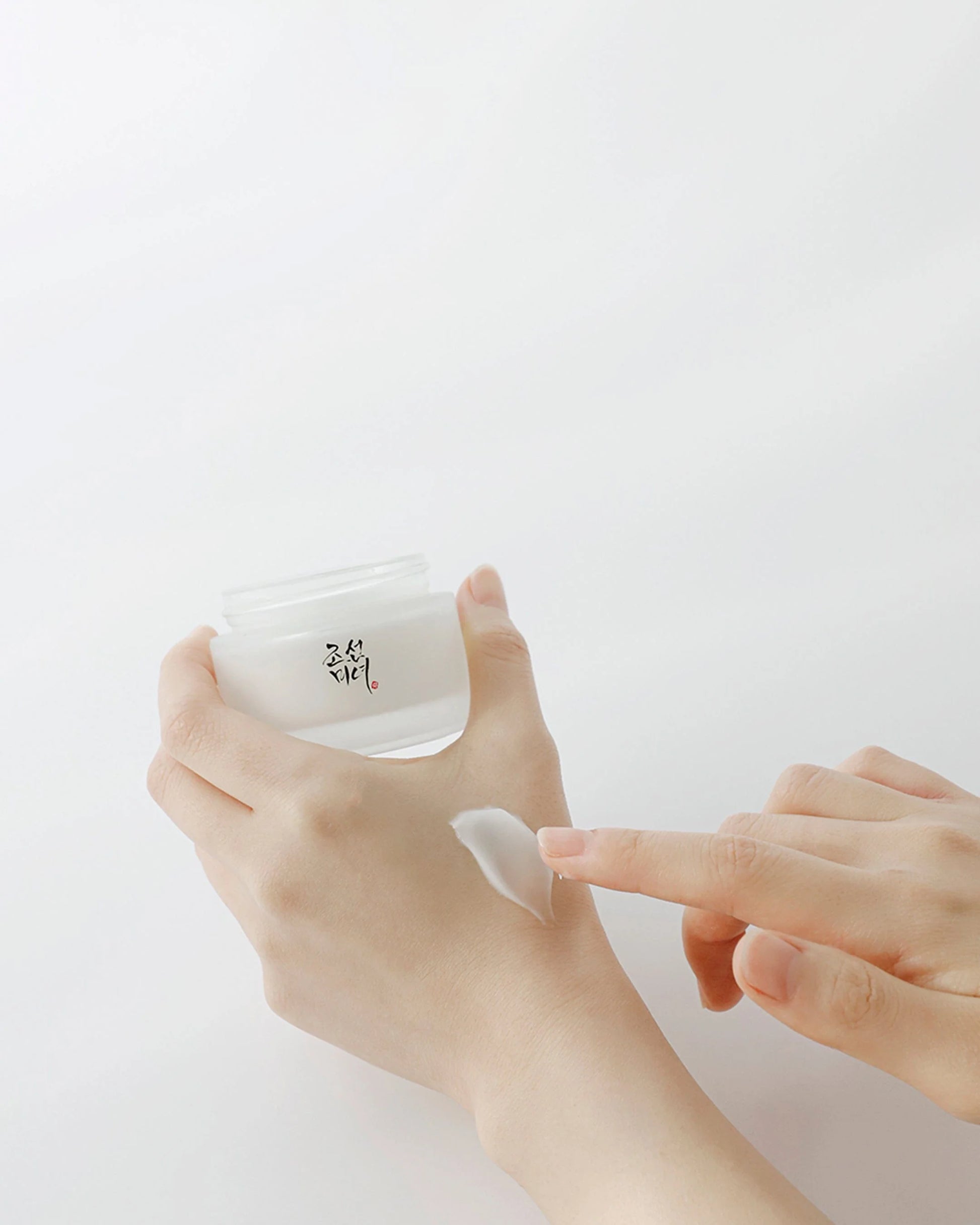 en kvinde påfør Beauty of Joseon Dynasty Cream på hånden. Koreansk hudpleje 