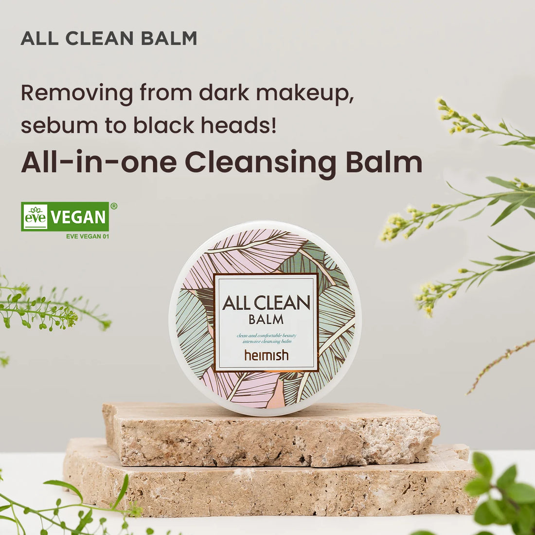 Heimish All Clean Balm på en stenplade med planter i baggrunden. Produktet fjerner mørk makeup, talg og hudorme. All-in-one Cleansing Balm. Vegansk certificeret