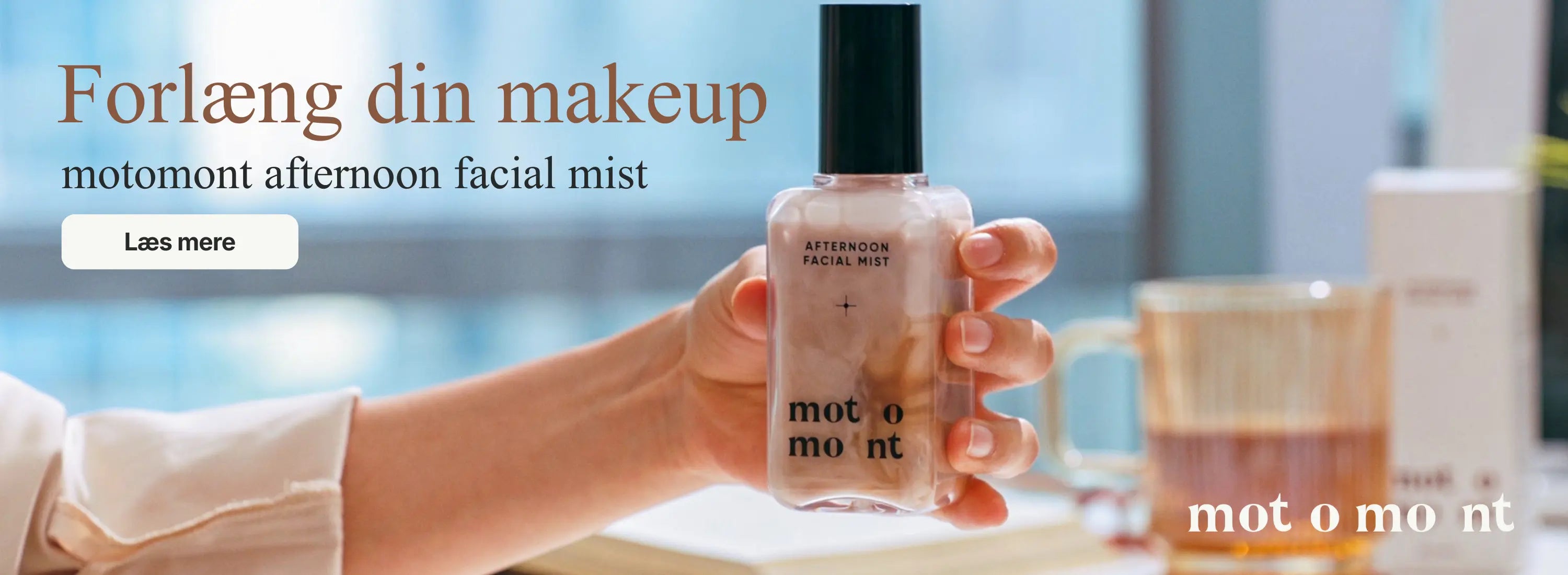 Hånd der holder Motomont flaske