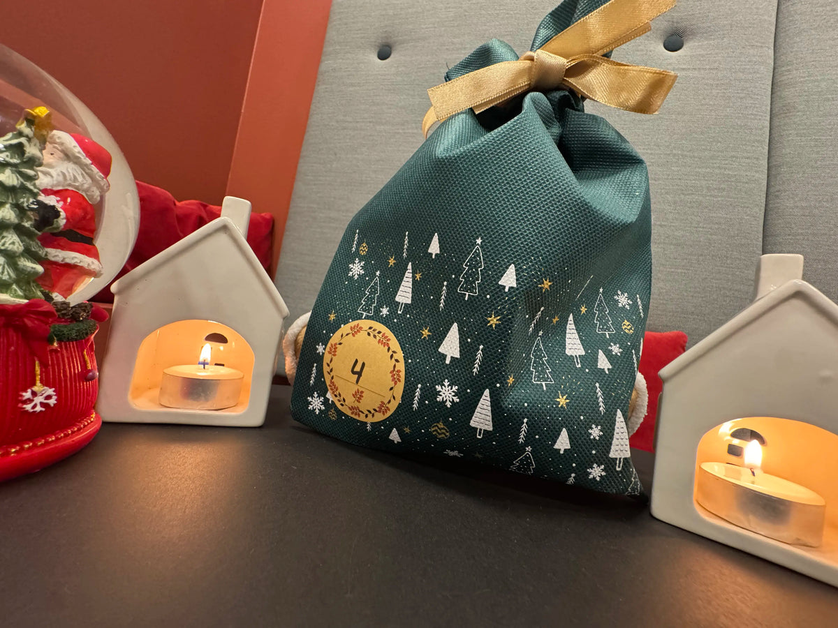 Komikos adventskalender: nummererede grønne stofposer med guldbånd.