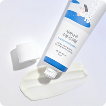 Round Birch Juice Moisturizing Sun Cream på hvid baggrund. En tube med fugtgivende solcreme, der er blevet åbnet, og noget af cremen er presset ud ved siden af tuben. Tuben har en blå og hvid etiket med koreansk skrift og en illustration af en person ved birketræer. SPF 50+ PA++++.